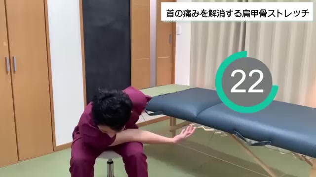 前傾して肩甲骨の外側を伸ばすストレッチの実演