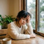 雨の日に頭痛でつらそうな小学生の女の子