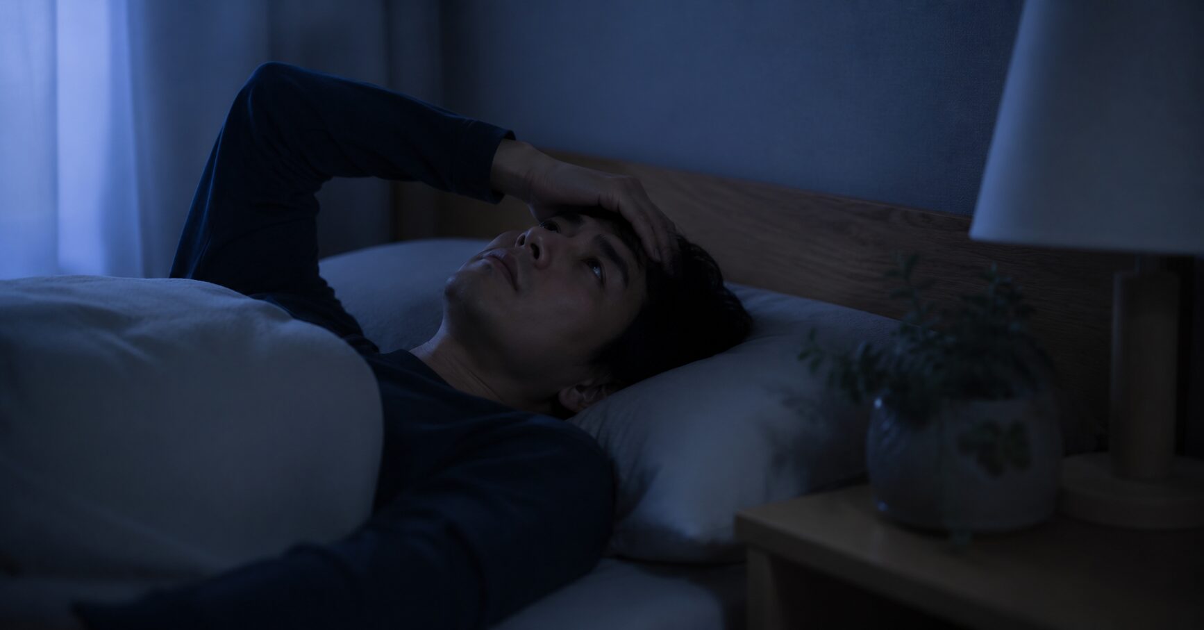 ベッドで眠れず天井を見つめる人